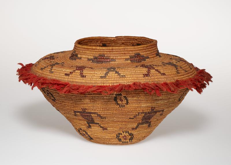 coiled basket; small foot with outward-flaring sides and wide, rather flat shoulder; short neck with wide mouth opening; red yarn fringe at point of shoulder; light brown with dark brown band of figures on shoulder and body; band of stepped diamonds on neck; repeating circular motifs above and below figures on body