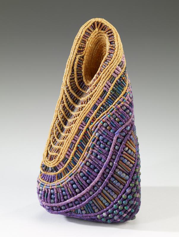 small, pyramid-shaped structure with indentation near top; woven bands and round and tube-shaped beads in purples, greens and yellows overall